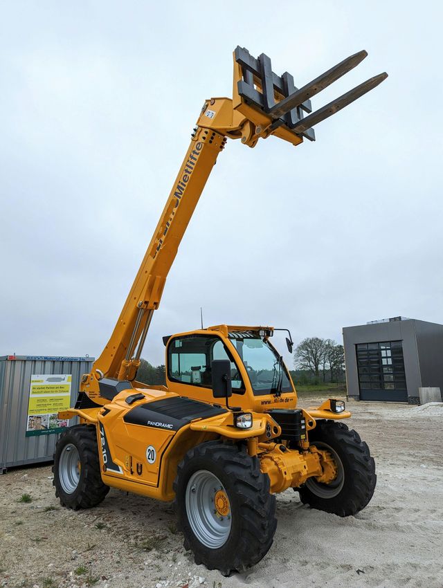 Yellow telehandler with forks in the air