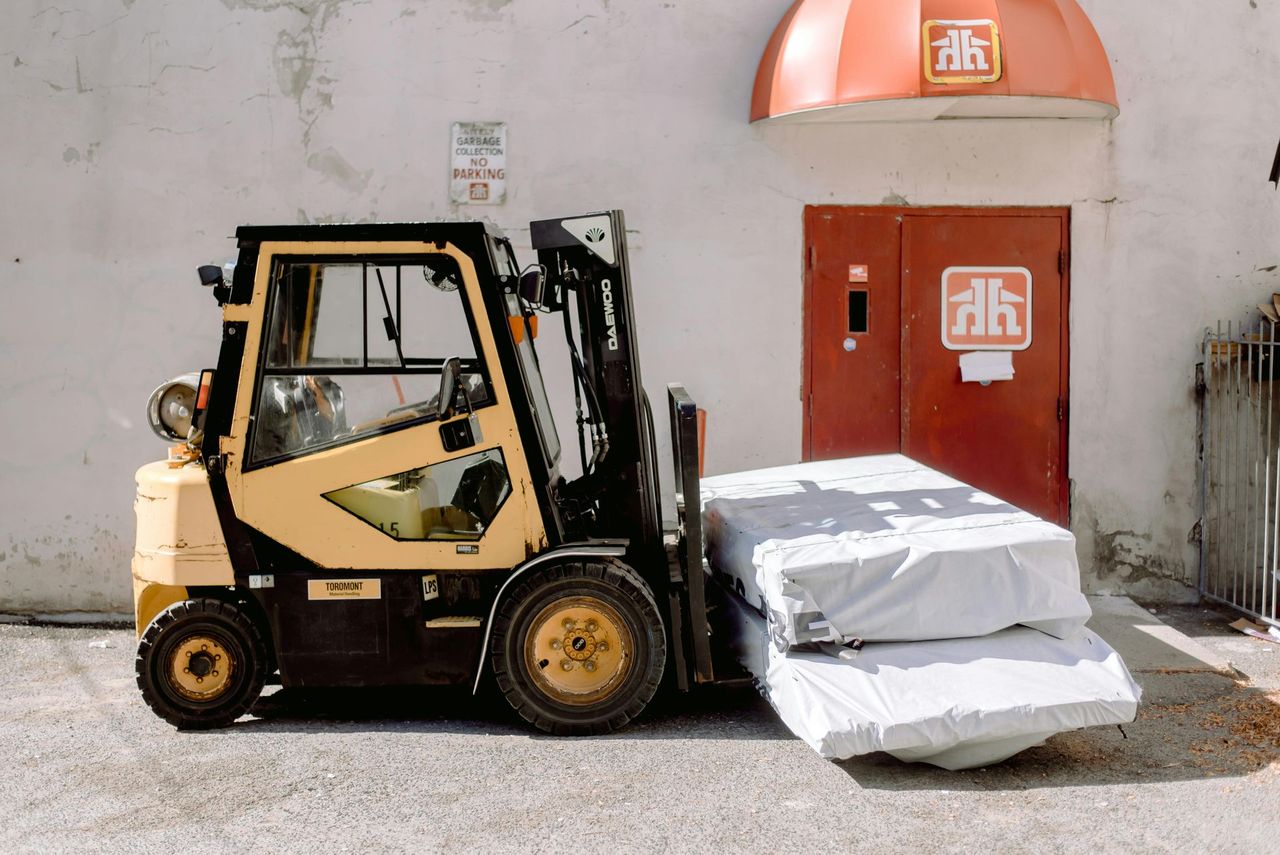 forklift lifting load of white boxes